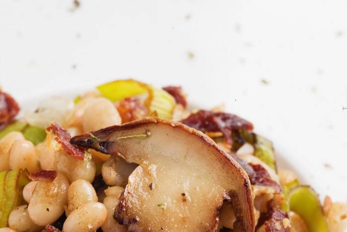 Alubias blancas salteadas con boletos, puerro y jamón