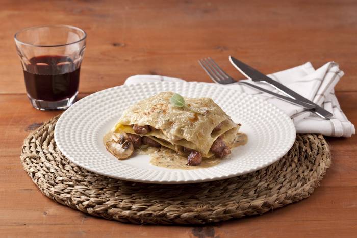 Lasaña fácil con espinacas, salchichas, cebolla confitada y setas