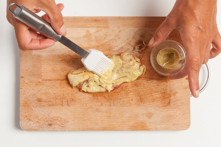 Untar la carne con mostaza