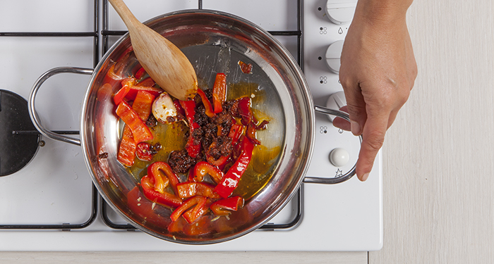 Añadir los pimientos a la salsa de tomate