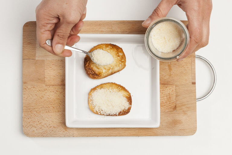 Espolvorear el pan con queso parmesano